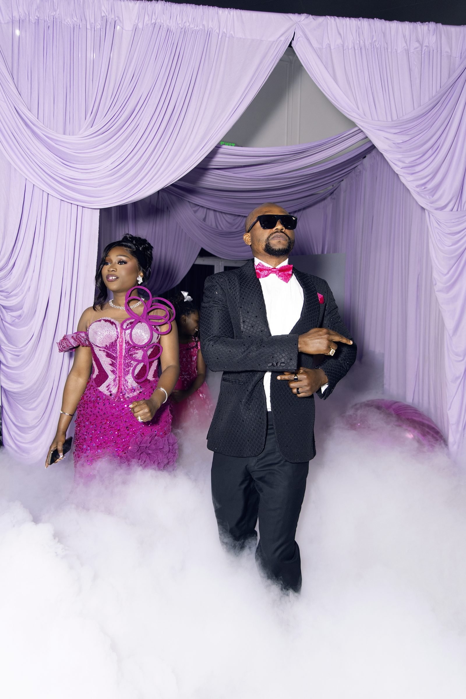 Couple making a grand entrance on a cloud of dry ice between lilac drapes in The Mansion at The Hendrix, Houston