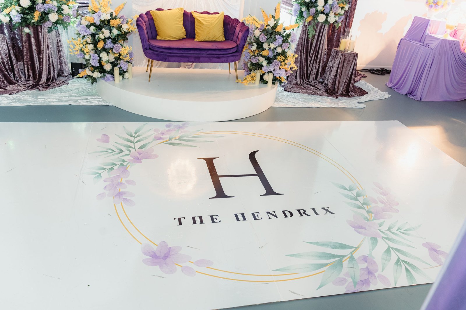 The Hendrix monogram on the floor of The Mansion with lounge seating and floral installations, Stafford, Houston