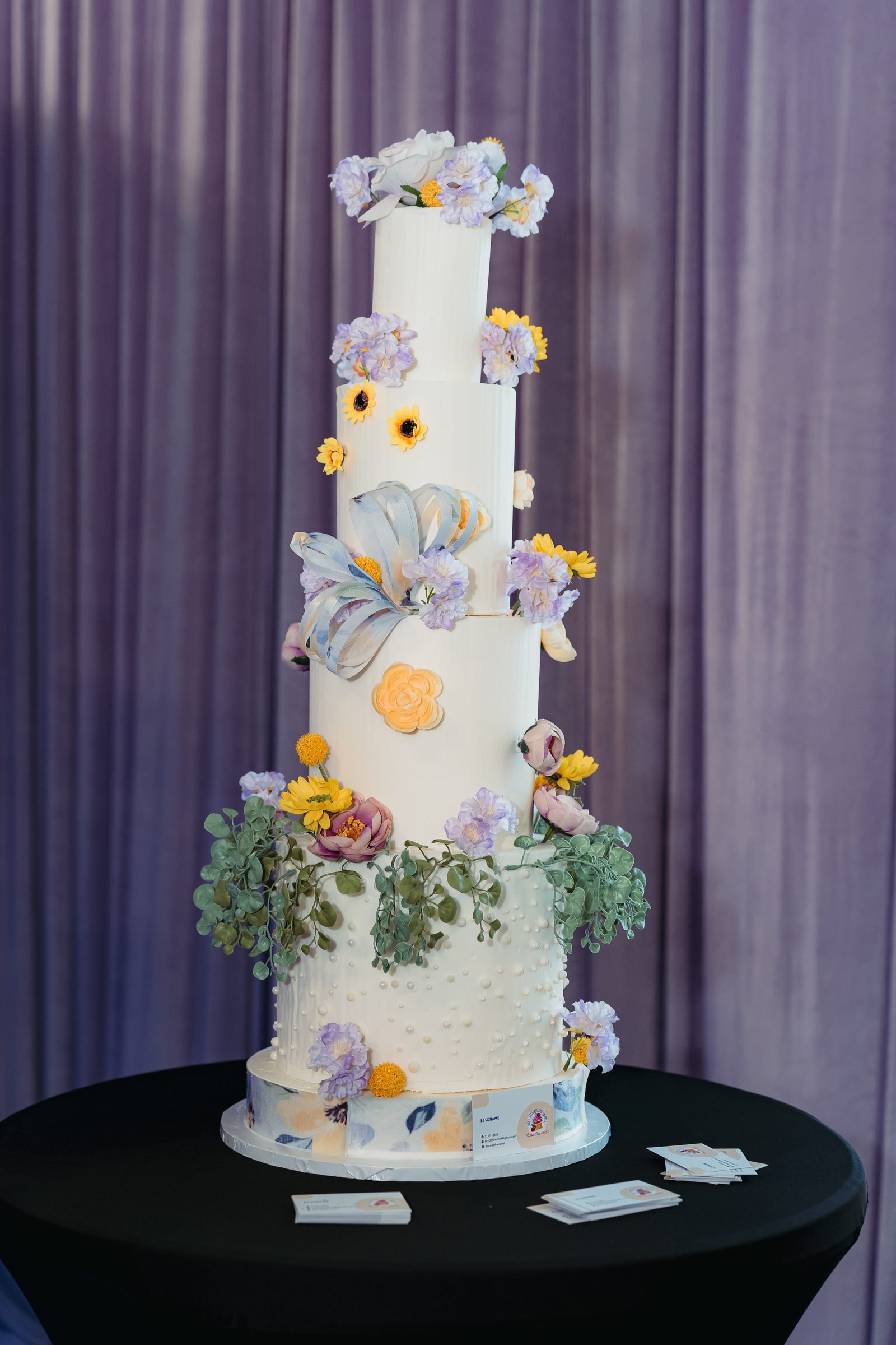 Tall tiered celebration cake with florals in The Mansion at The Hendrix, Stafford, Houston