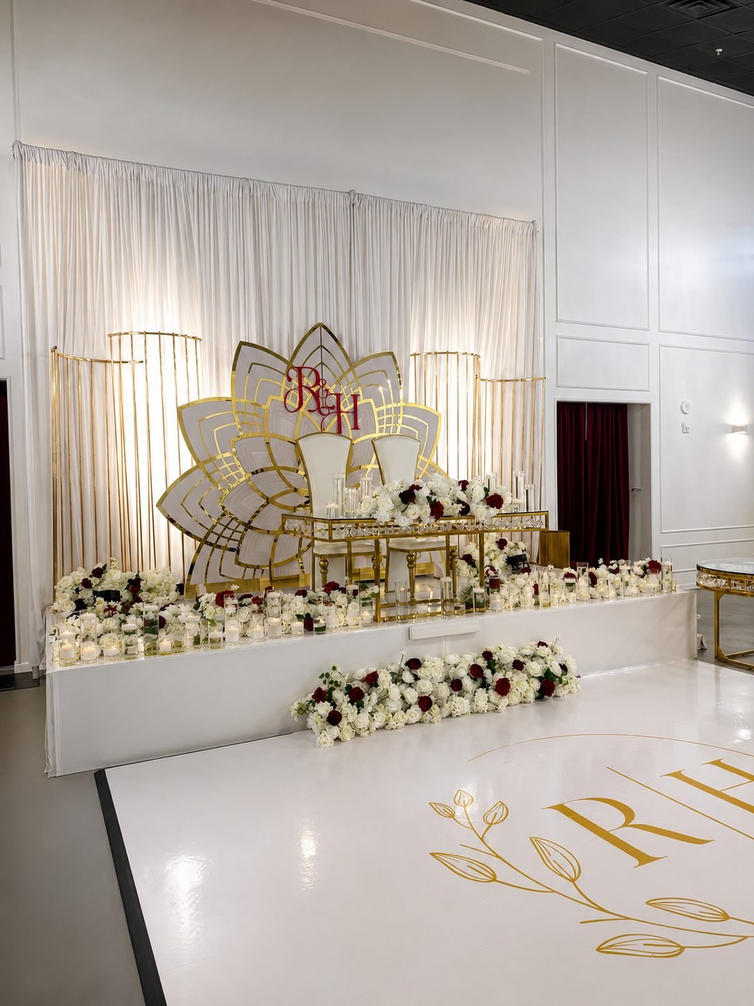Monogrammed head table with gold floral installation and white dance floor in The Mansion at The Hendrix