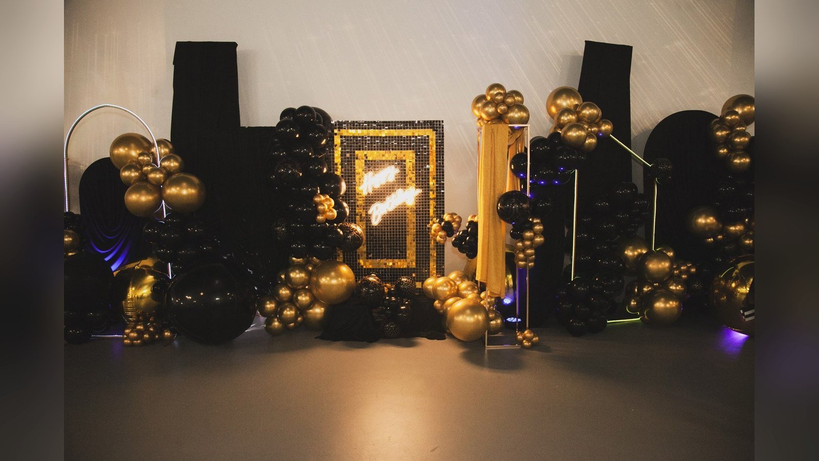 A black and gold balloon installation with a gilt frame at a milestone birthday at The Hendrix, Stafford, Houston