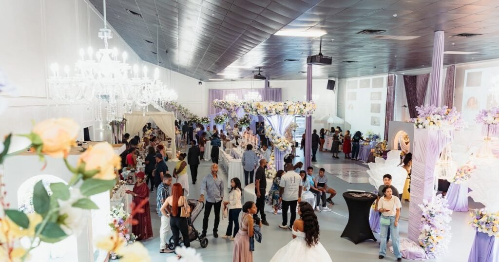Guests filling the Mansion at The Hendrix in Stafford, Houston, under crystal chandeliers during a party