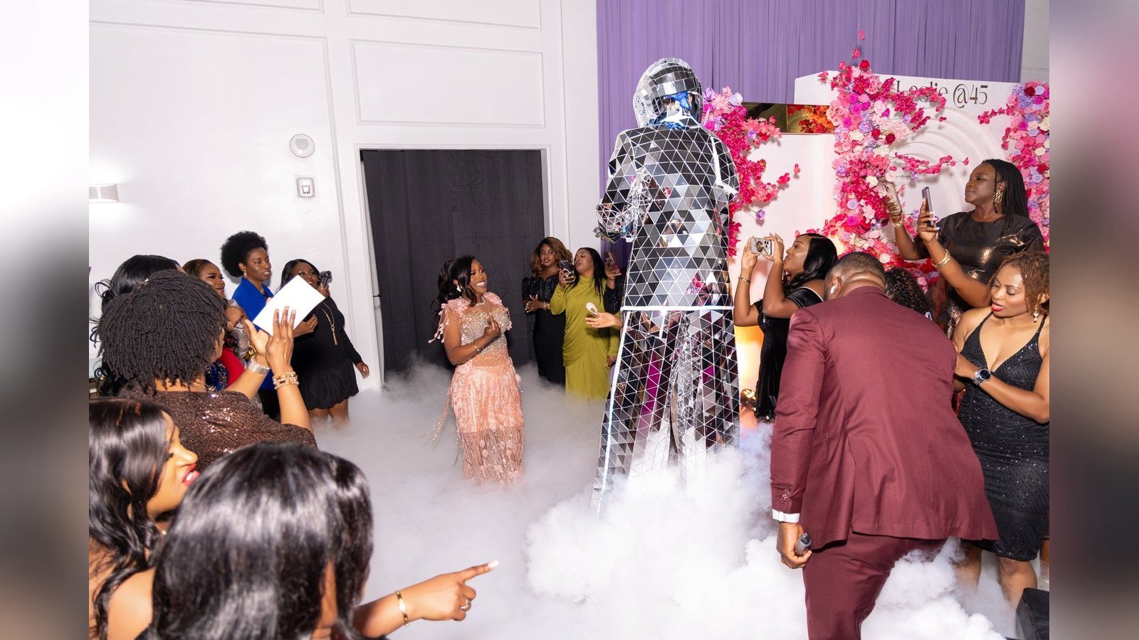 Guests dancing in aso-ebi under smoke effects at a Nigerian celebration in The Mansion at The Hendrix, Stafford, Houston