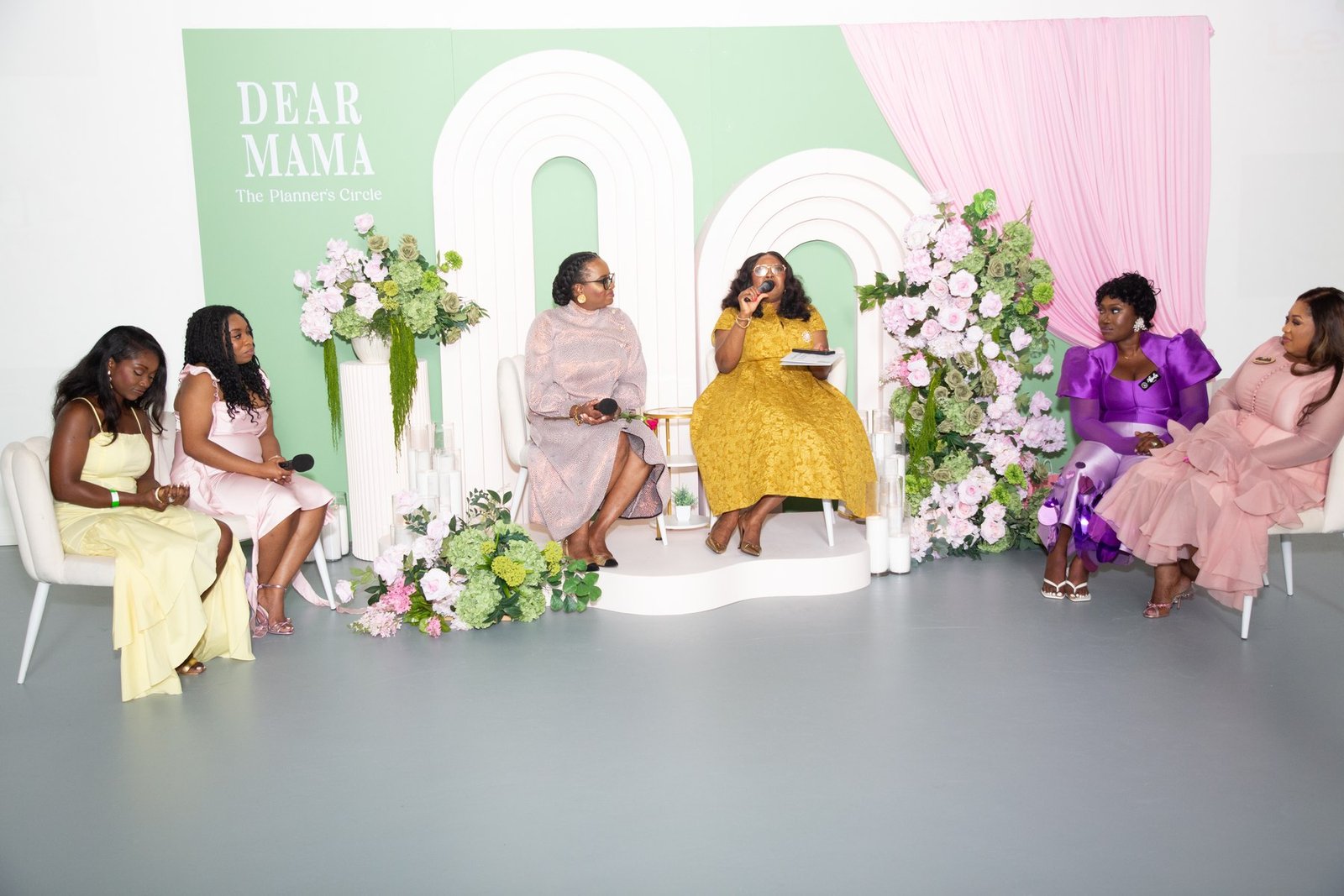 The Dear Mama stage at The Hendrix with guests seated across it and one speaking into a microphone