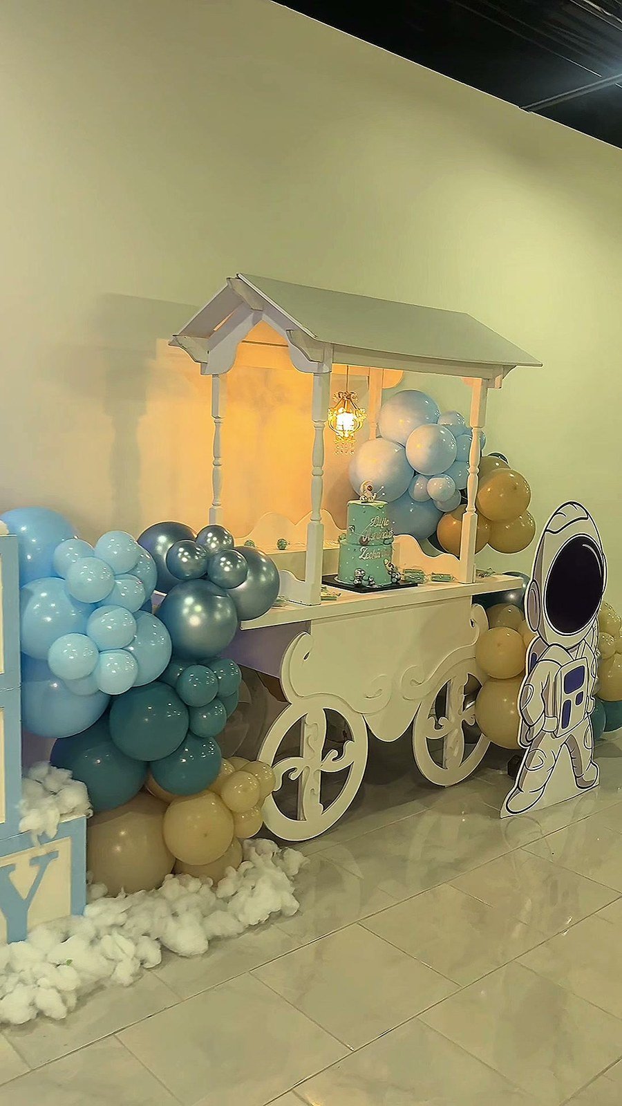 A white baby carriage and BABY blocks beside a balloon garland at The Hendrix