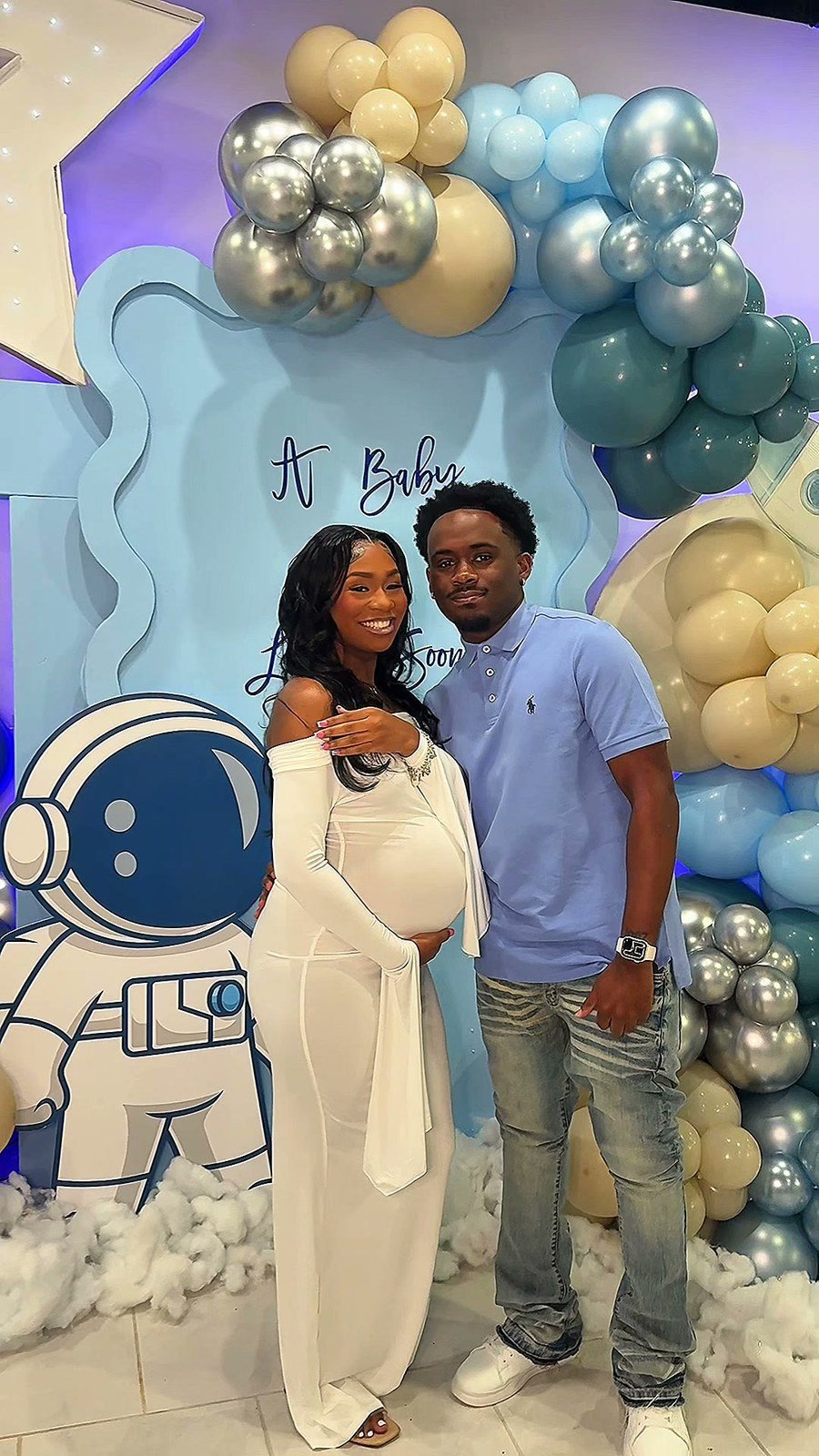 The parents-to-be photographed in front of the astronaut backdrop at their baby shower at The Hendrix