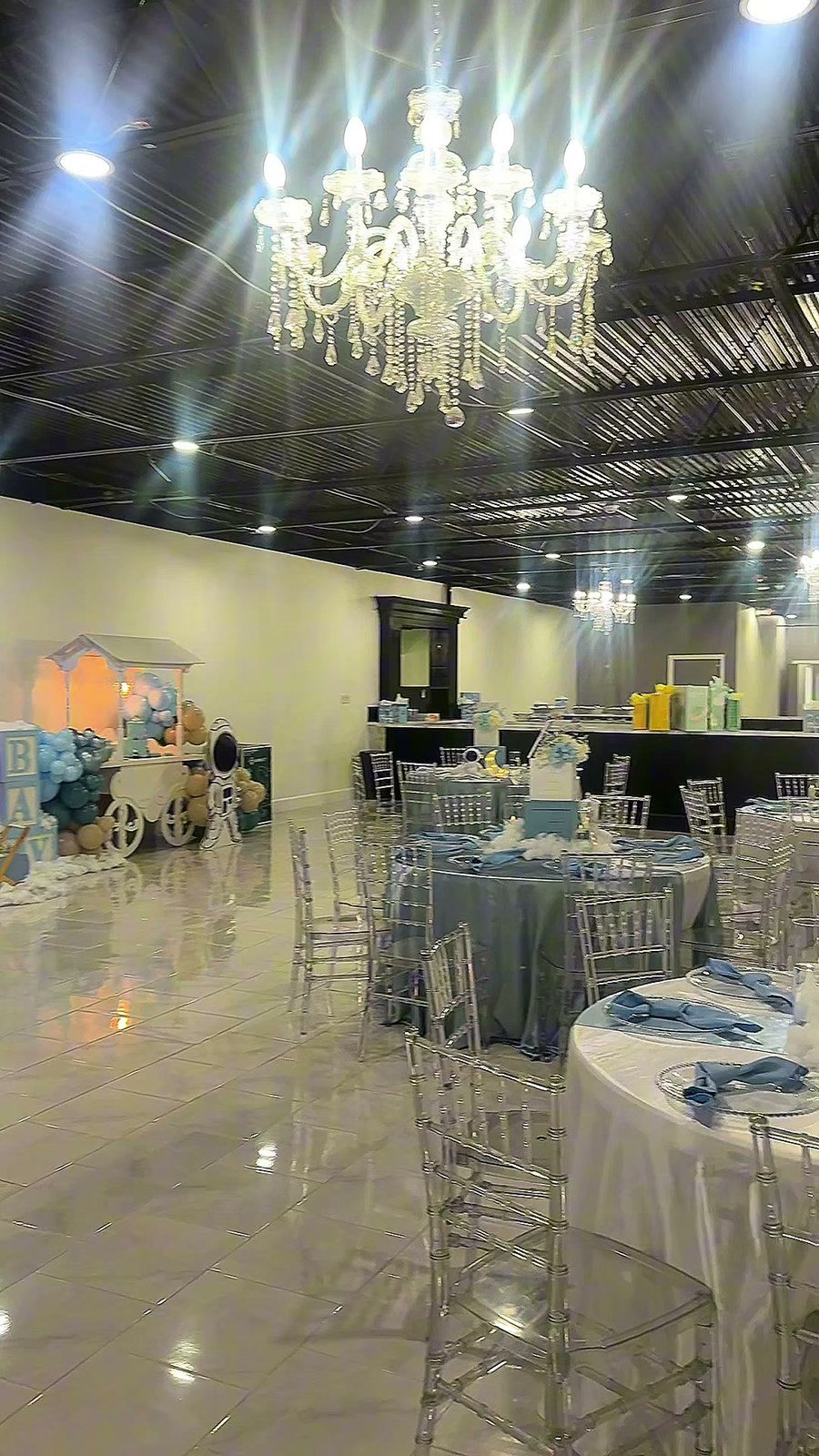 Round tables dressed in blue and silver under crystal chandeliers in The Dome at The Hendrix, set for a small party
