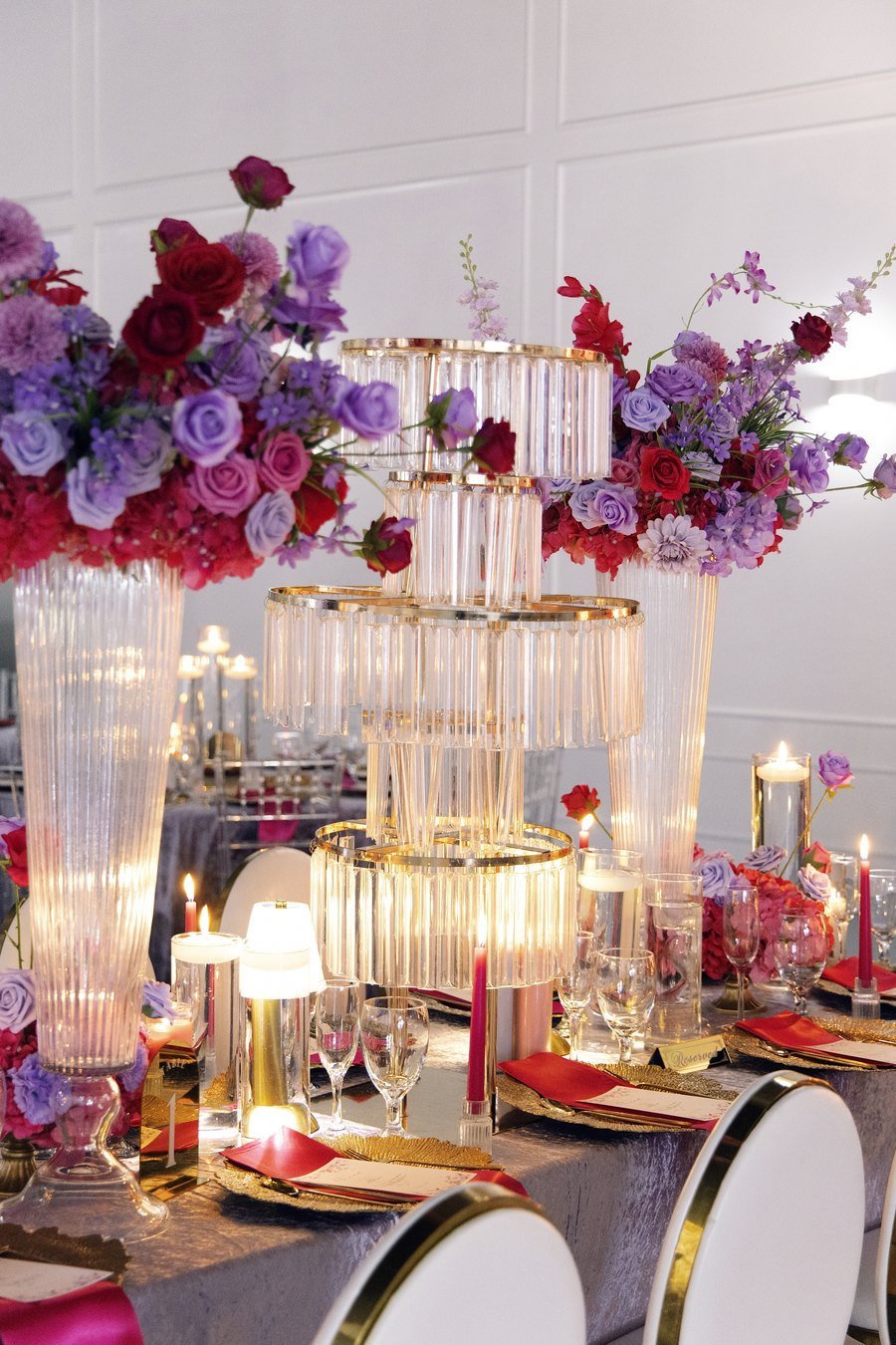 A tall rose and hydrangea centrepiece on a ribbed glass stand against the panelled wall at The Hendrix