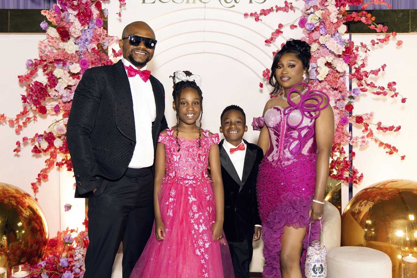 The celebrant with her husband, daughter and son in front of the cherry blossom arch at The Hendrix