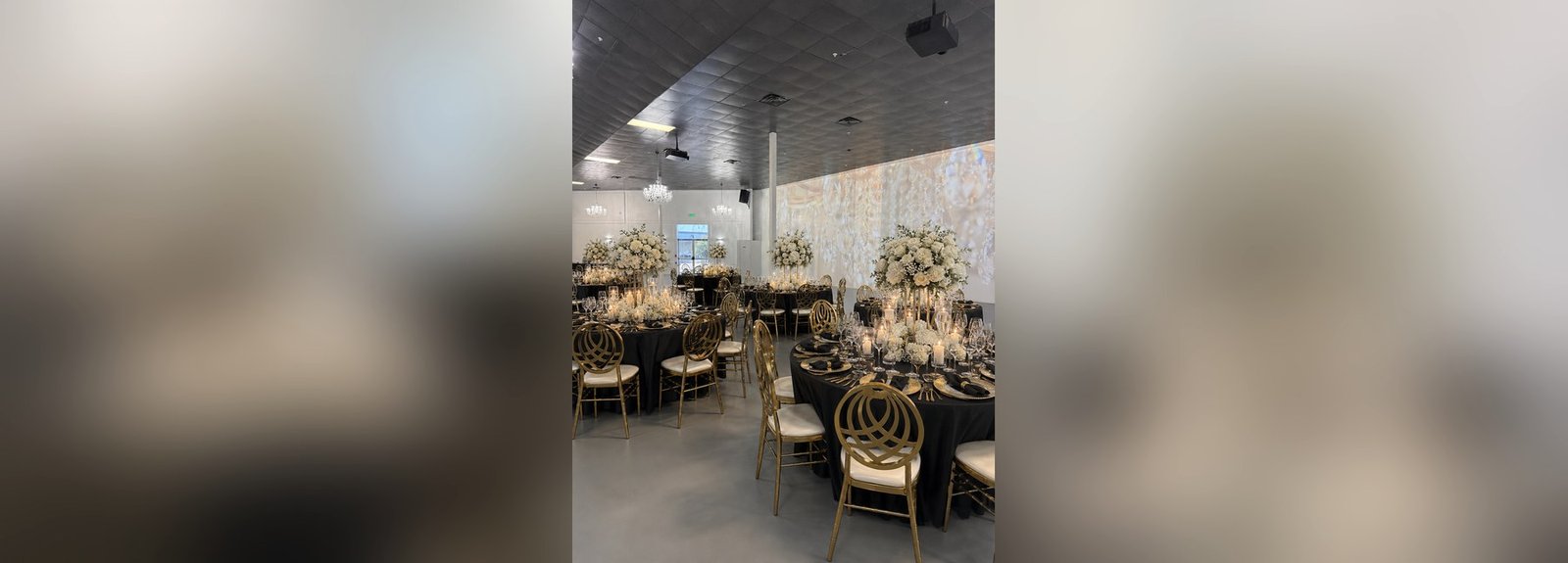The Mansion at The Hendrix dressed in black and gold with white florals and an illuminated floral wall