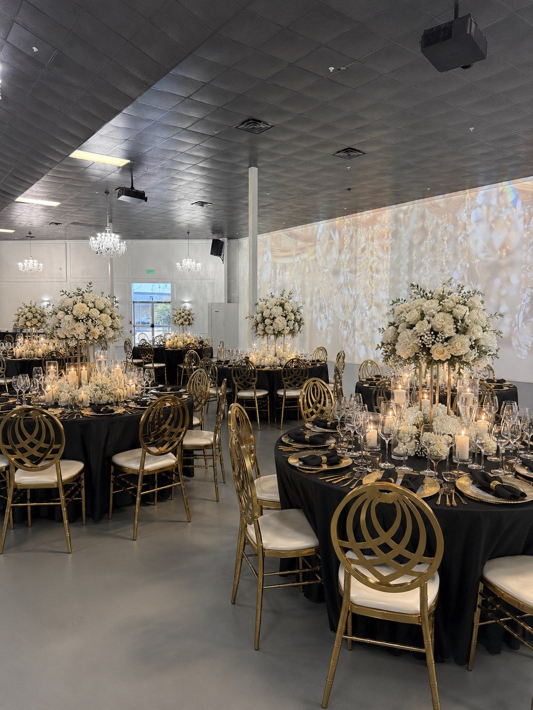 The Mansion at The Hendrix dressed in black and gold with white florals and an illuminated floral wall