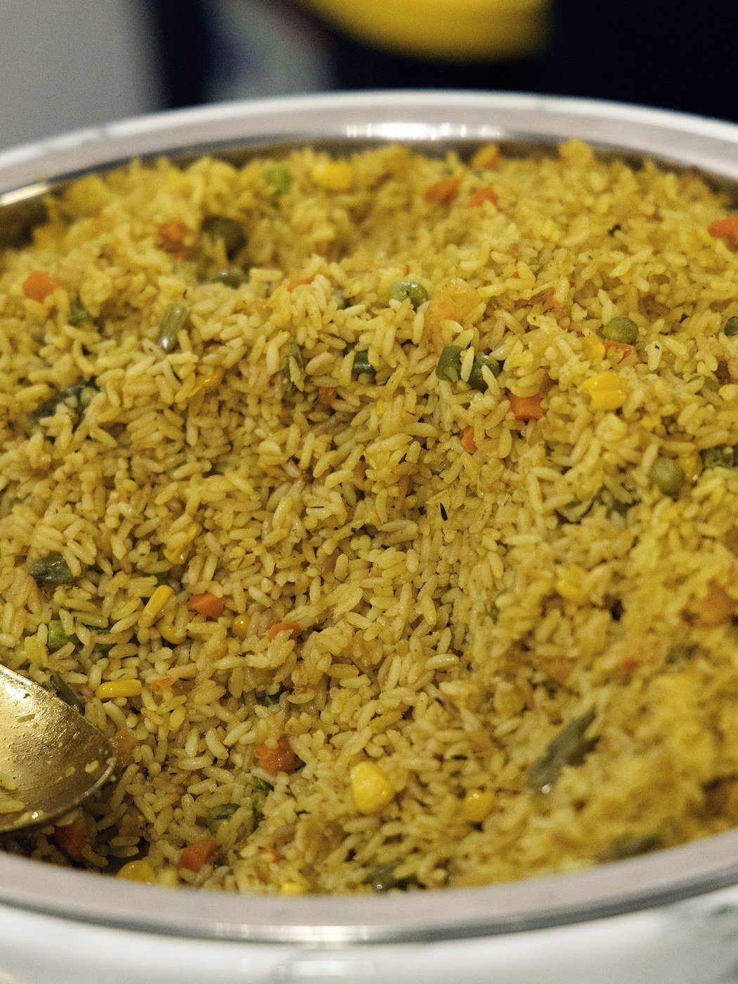 A chafing dish of party fried rice with a gold serving spoon at an event catered at The Hendrix