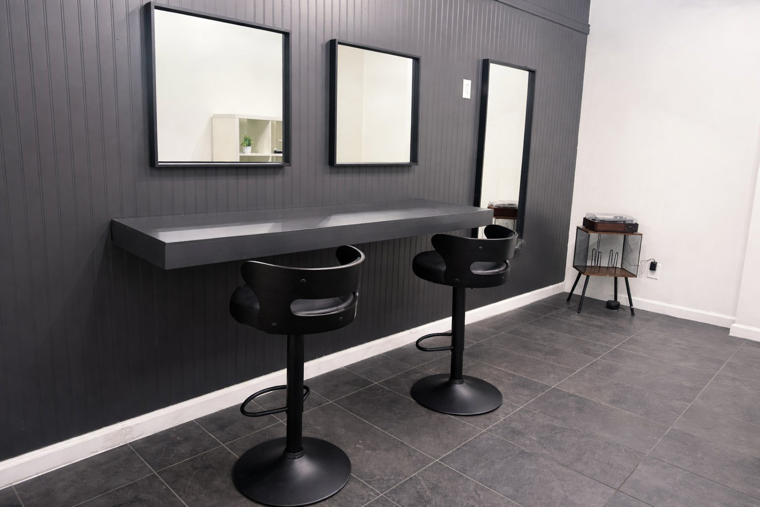A dark vanity counter with black stools in the second suite at The Hendrix