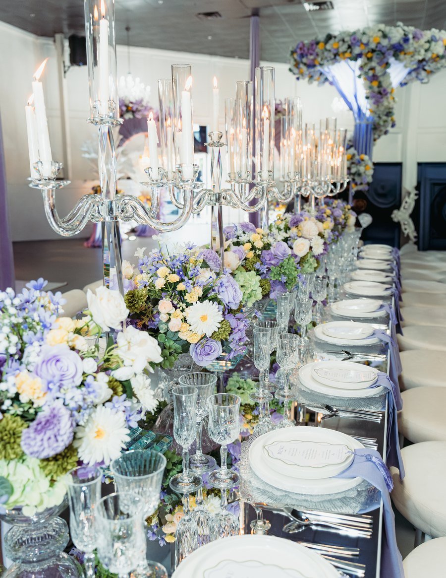 A mirror-top banquet table with candelabra and lilac florals at The Hendrix