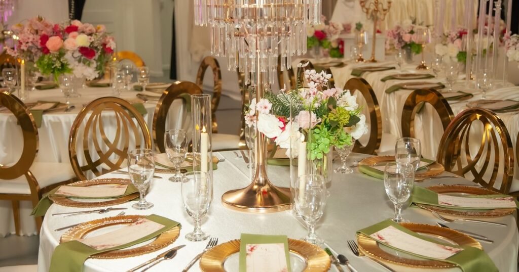 Round reception tables with rose centrepieces, crystal candelabra and gold chairs in the Mansion at The Hendrix, Stafford